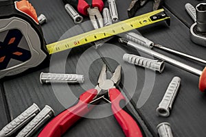 DIY tool set. Nylon plugs, pliers and flexometer with screwdrivers