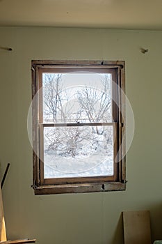 DIY window insert install in old house with wintery snow and trees in view