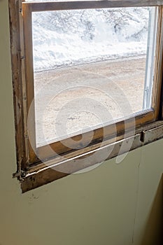 DIY window insert install in old house with wintery snow and trees in view