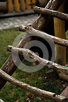 DIY wooden playhouse for children with slide on a hillside in a sunny day. Modern unusual bright wooden playground children\'s