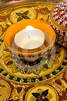 Diya lamp on a decorated golden plate