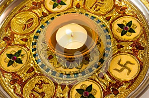 Diya lamp on a decorated golden plate