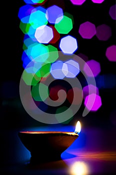 Diya lightened during diwali festival of Hindu religion in India. Colorful bokeh light background. Used selective focus