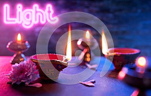 Diya oil lamps on neon light background