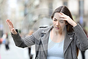 Dizzy woman feeling sick on street photo