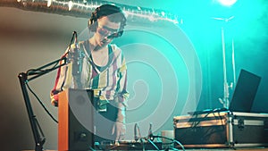 DJ artist using clubbing mixing turntables at party