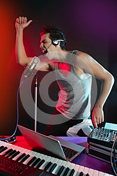 Dj with colorful light and music mixing equipment