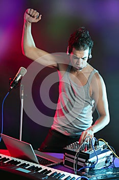 Dj with colorful light and music mixing equipment