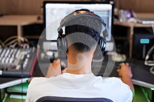 DJ, computer and man in recording studio for music producer with tech and headphones. Sound engineer, audio technician