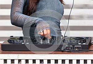 A DJ girl controls the mixing console