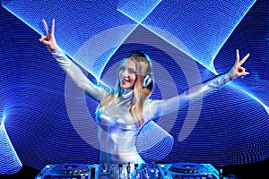 DJ girl on decks at the party gesturing V sign