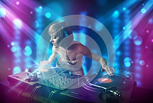 Dj girl mixing music in a club with blue and purple lights