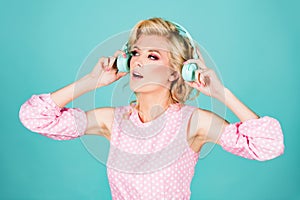 Dj girl. Young blonde woman in headphones listening music isolated on blue studio background.