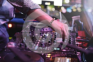 DJ hand playing live set and mixing music on controller turntable console mixing desk at stage in the night club, music beach