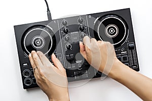 DJ hands mixing music on DJ Digital mixing controller top view on white background