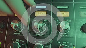 DJ manipulates button of equalizer to create dynamic mix