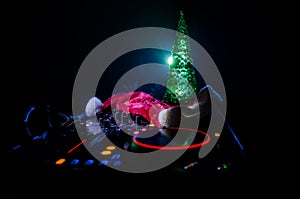 Dj mixer with headphones on dark nightclub background with Christmas tree New Year Eve. Close up view of New Year elements or symb