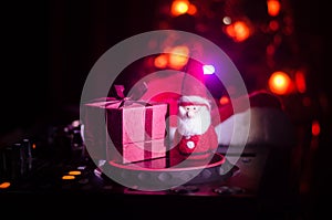 Dj mixer with headphones on dark nightclub background with Christmas tree New Year Eve. Close up view of New Year elements or symb