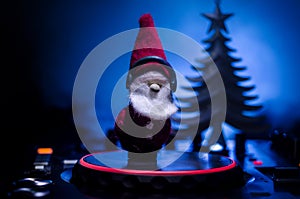 Dj mixer with headphones on dark nightclub background with Christmas tree New Year Eve. Close up view of New Year elements or symb