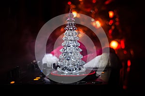 Dj mixer with headphones on dark nightclub background with Christmas tree New Year Eve. Close up view of New Year elements or symb