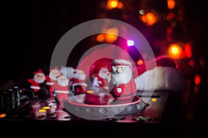 Dj mixer with headphones on dark nightclub background with Christmas tree New Year Eve. Close up view of New Year elements or symb