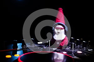 Dj mixer with headphones on dark nightclub background with Christmas tree New Year Eve. Close up view of New Year elements or symb
