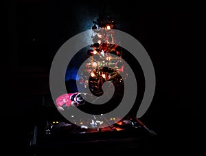 Dj mixer with headphones on dark nightclub background with Christmas tree New Year Eve. Close up view of New Year elements or symb