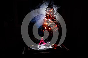 Dj mixer with headphones on dark nightclub background with Christmas tree New Year Eve. Close up view of New Year elements or symb