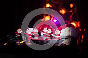 Dj mixer with headphones on dark nightclub background with Christmas tree New Year Eve. Close up view of New Year elements or symb