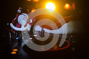 Dj mixer with headphones on dark nightclub background with Christmas tree New Year Eve. Close up view of New Year elements or symb