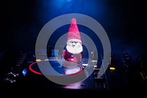 Dj mixer with headphones on dark nightclub background with Christmas tree New Year Eve. Close up view of New Year elements or symb