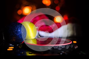 Dj mixer with headphones on dark nightclub background with Christmas tree New Year Eve. Close up view of New Year elements or symb