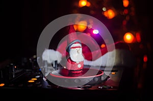 Dj mixer with headphones on dark nightclub background with Christmas tree New Year Eve. Close up view of New Year elements or symb