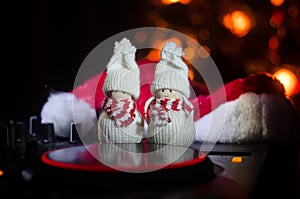 Dj mixer with headphones on dark nightclub background with Christmas tree New Year Eve. Close up view of New Year elements or symb