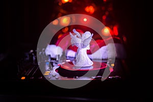 Dj mixer with headphones on dark nightclub background with Christmas tree New Year Eve. Close up view of New Year elements or symb