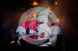 Dj mixer with headphones on dark nightclub background with Christmas tree New Year Eve. Close up view of New Year elements or symb