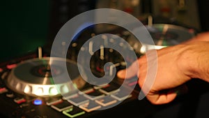 DJ mixes songs on equipment, hands closeup