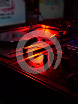 DJ Mixing Deck Under Orange Tech Lights