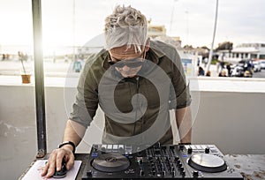 Dj mixing music outdoor at beach party festival - Summer nightlife view of disco club at sunset - Fun, millennials generation,