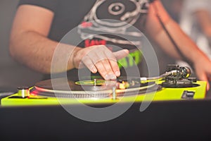 DJ mixing music on vinyl record at the night club