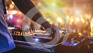 Dj mixing outdoor at beach party festival with crowd of people in background - Summer nightlife view of disco club outside - Soft
