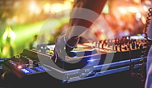 Dj mixing outdoor at beach party festival with crowd of people in background - Summer nightlife view of disco club outside - Soft photo