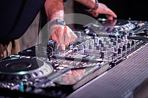 Dj playing disco house progressive electro music at the concert. DJ hands on equipment