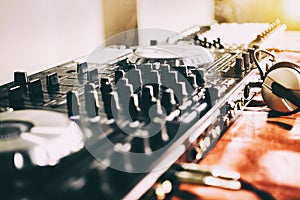 DJ playing music at mixer closeup and mixes the track in the nightclub