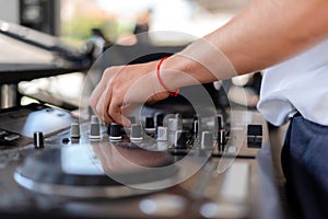 DJ playing music at outdoor event. Person operating mixer at music festival. Close up shot of deejay mixing at the party