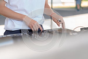 DJ playing music at outdoor event. Person operating mixer at music festival. Close up shot of deejay mixing at the party