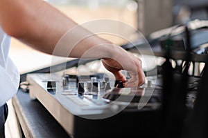 DJ playing music at outdoor event. Person operating mixer at music festival. Close up shot of deejay mixing at the party