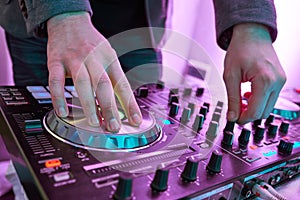 DJ plays and mix music on digital midi mixer controller.