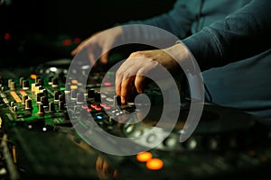 Dj`s hand is mixing tracks at party in night club.