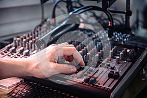 DJ& x27;s hand touching the audio control panel